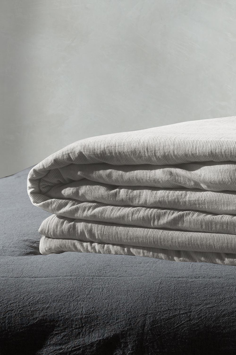 Folded striped bedding on a bed